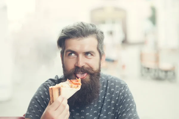 Knappe bebaarde man eten pizza — Stockfoto