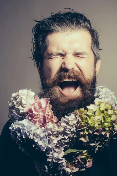 Homem barbudo com flores de hortênsia — Fotografia de Stock