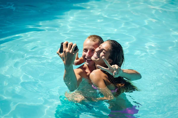 Feliz pareja joven en la piscina — Foto de Stock