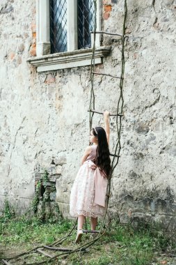 İp merdiven üzerinde elbiseli küçük kız