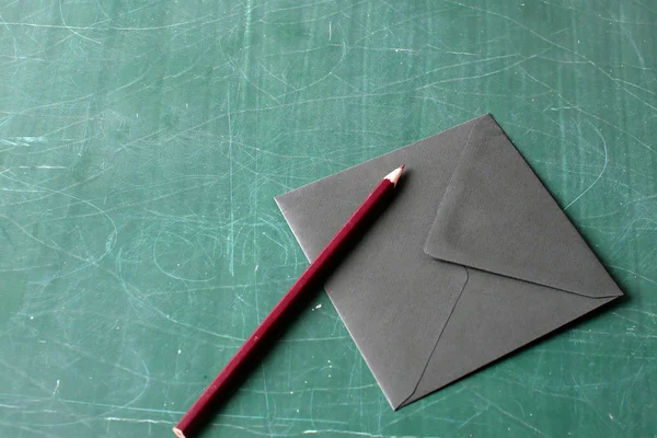 Red pencil and black envelope — Stock Photo, Image