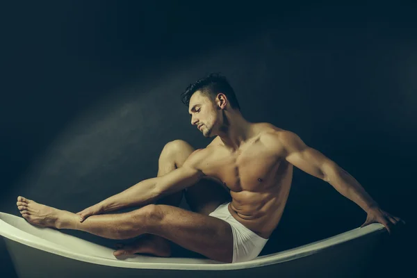 Muscular man on bathtub — Stock Photo, Image