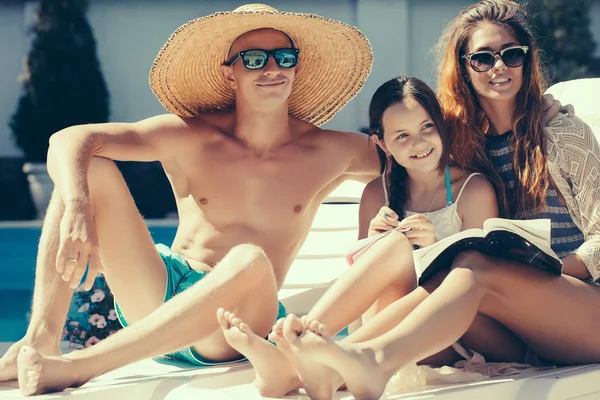 Feliz joven familia en la piscina — Foto de Stock