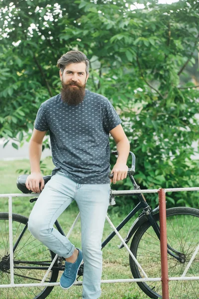 Handsome man with beard with the bike outside