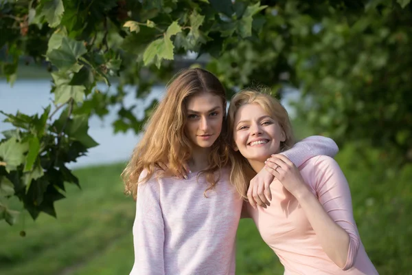Twee meisjes knuffel en glimlach — Stockfoto