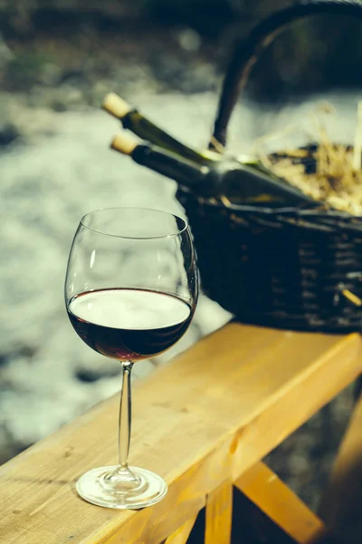 Wine glass and bottles in basket