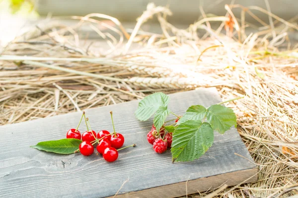 Ciliegia e lampone su tavola di legno — Foto Stock