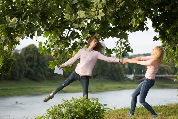 Två unga flickor håller händer — Stockfoto