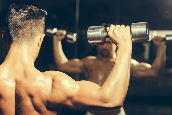 Hombre musculoso con mancuerna — Foto de Stock