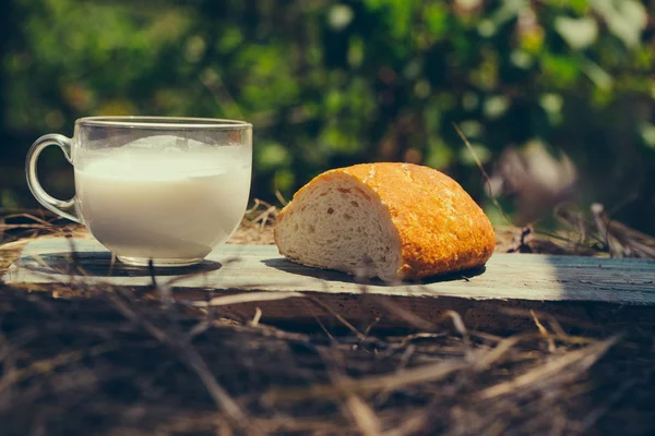 Bröd och mjölk cup på träskiva — Stockfoto