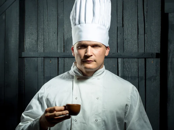 Male chef in white uniform and hat with cup — Stock Photo, Image