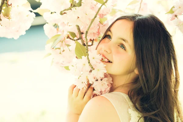 Small smiling girl in blossom — Stock Photo, Image