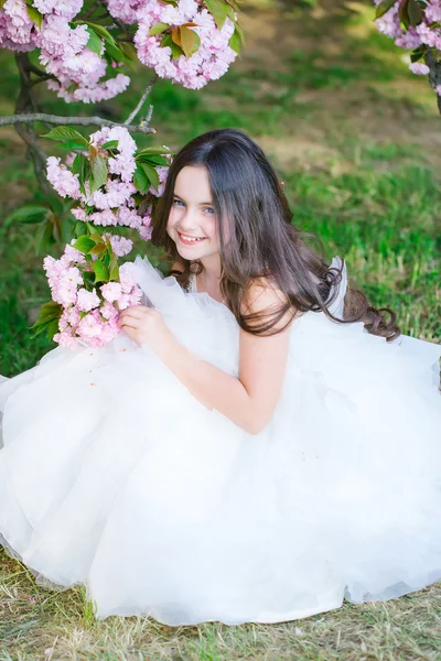 Klein meisje in roze bloei — Stockfoto