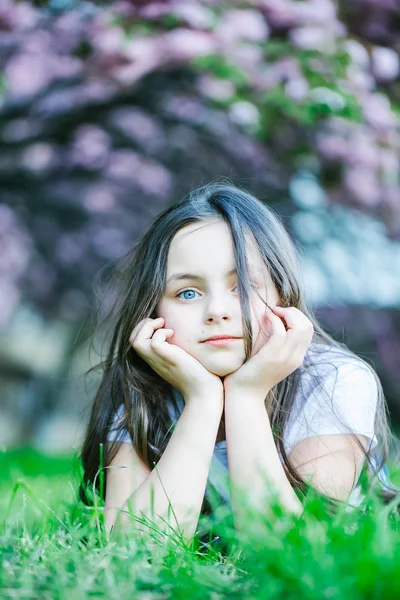 Kleines Mädchen auf blühendem Gras — Stockfoto