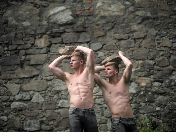 Gêmeos musculares na parede pedregosa — Fotografia de Stock