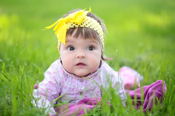 Cute baby girl on green grass — Stock Photo, Image