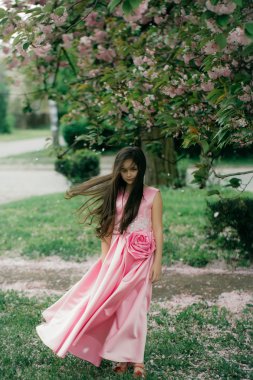 Çiçeği ile pembe elbiseli küçük kız