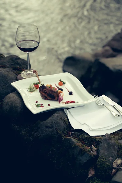 Винний келих і їжа біля води — стокове фото