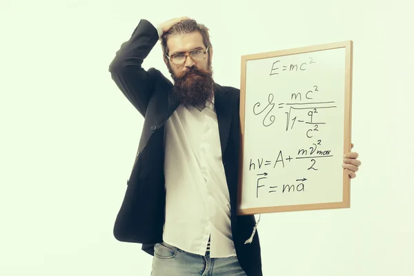 Бородатый человек с формулой Эйнштейна и законом Ньютона — стоковое фото