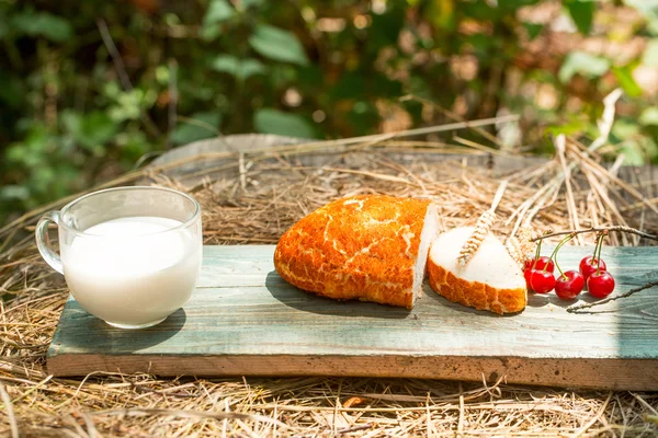 Bread cherry and cup of milk — Stock Photo, Image