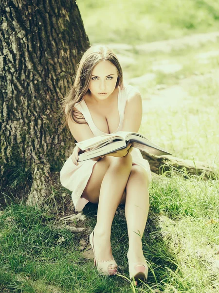 Güzel kadınla çimenlerin üzerinde kitap okuma — Stok fotoğraf