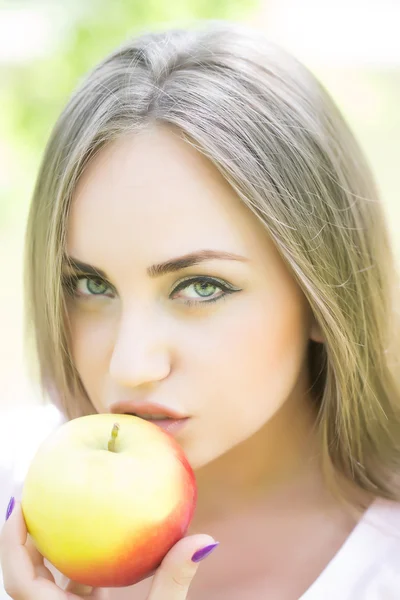 Young beautiful woman eats apple — Stockfoto