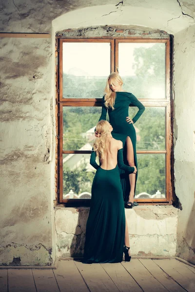 Pretty women in green dresses near window — Stock Photo, Image