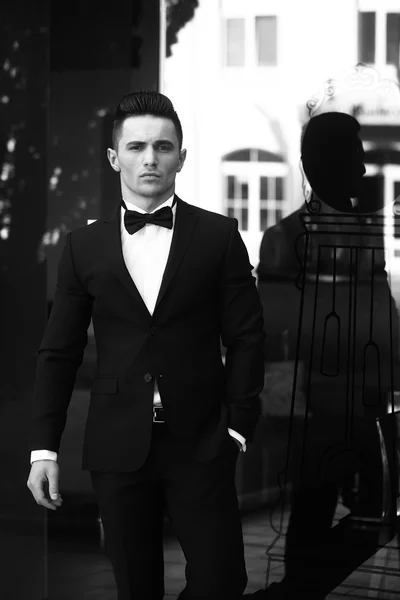 Young man in suit near glass door — Stock Photo, Image