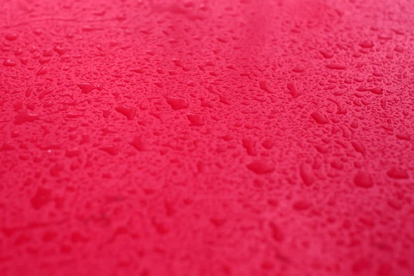 Regnet droppar på röd bakgrund — Stockfoto