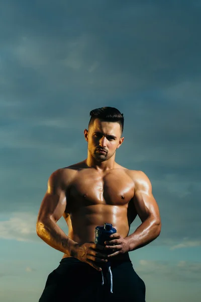 Hombre musculoso húmedo con botella de agua — Foto de Stock