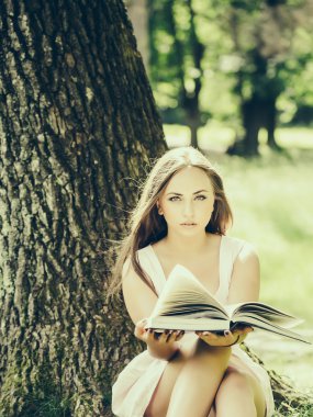 güzel kadınla çimenlerin üzerinde kitap okuma