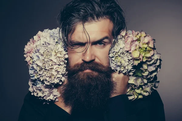 Homem barbudo com flores de hortênsia — Fotografia de Stock