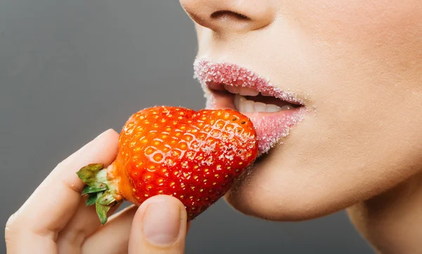 Dişi şeker dudaklar kırmızı çileği ısırır — Stok fotoğraf