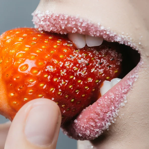 Dişi şeker dudaklar kırmızı çileği ısırır — Stok fotoğraf