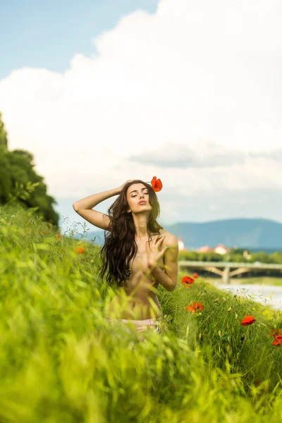 Naken kvinna i grönt fält med vallmo — Stockfoto