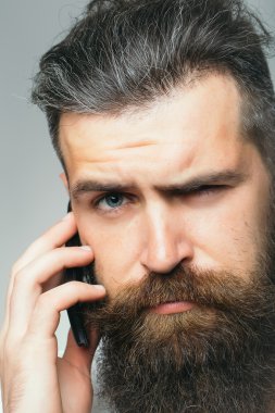 Sakallı adam cep telefonu ile