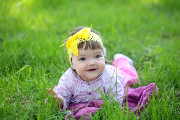 Cute baby girl on green grass — Stock Photo, Image