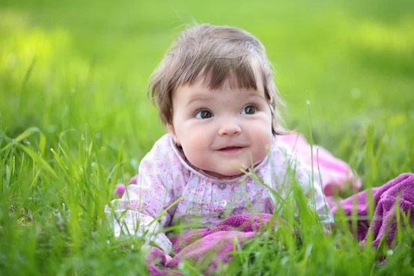 Cute dziewczynka na zielonej trawie — Zdjęcie stockowe