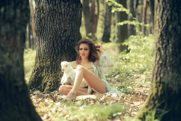 Jonge vrouw met geit in bos — Stockfoto