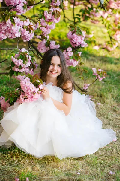 Klein meisje in roze bloei — Stockfoto