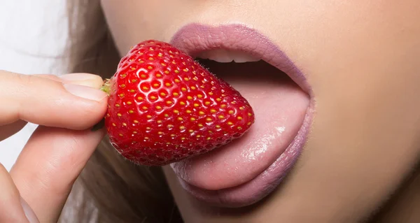 Labios femeninos comiendo fresa roja — Foto de Stock