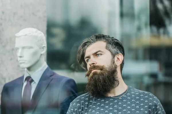 Бородатый человек рядом с витриной с манекеном — стоковое фото