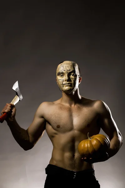 Мускулистый человек в маске с тыквой — стоковое фото