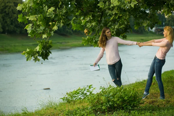 Två unga flickor håller händer — Stockfoto