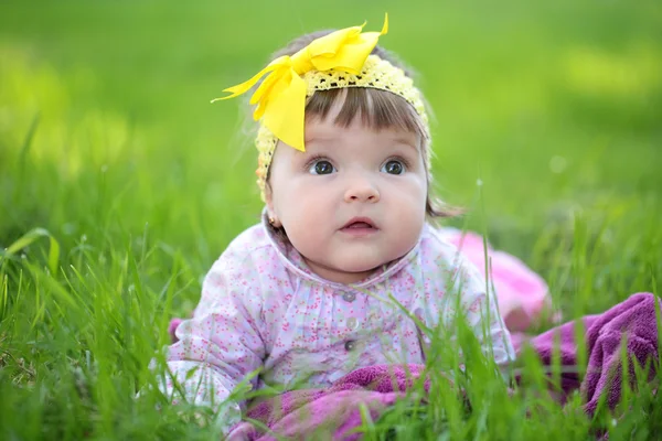 Cute baby girl on green grass — Stock Photo, Image