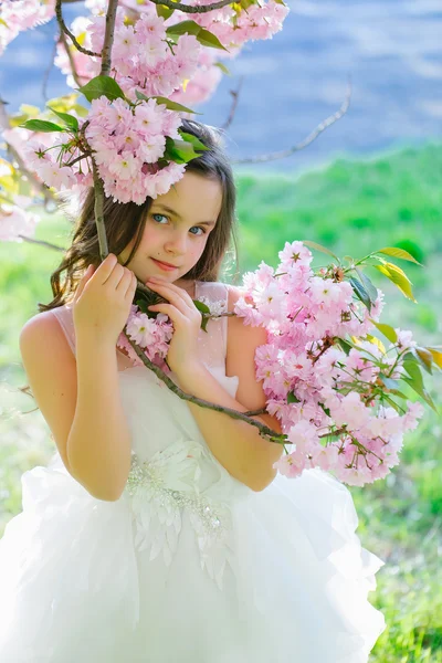 Little girl in spring bloom — Stock Photo, Image