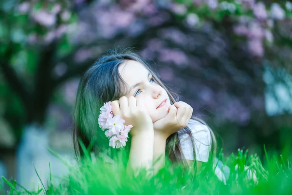 Bambina sull'erba in fiore — Foto Stock