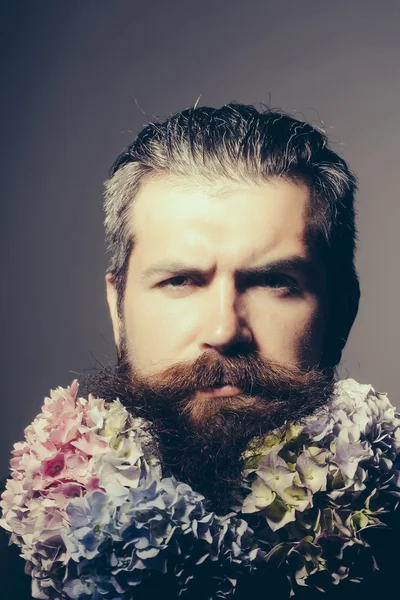 Homem barbudo com flores de hortênsia — Fotografia de Stock