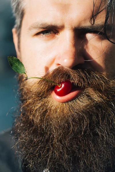 Homem barbudo com cereja vermelha — Fotografia de Stock