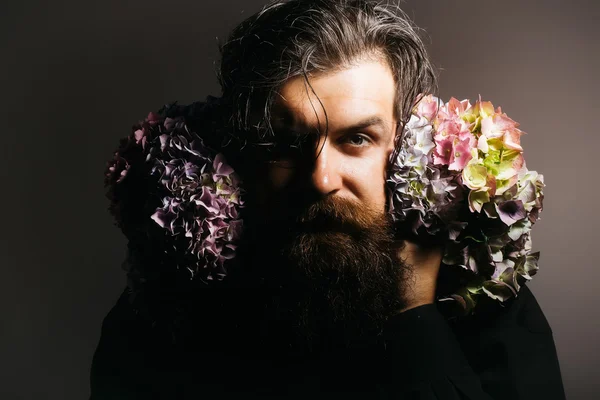 Homem barbudo com flores de hortênsia — Fotografia de Stock